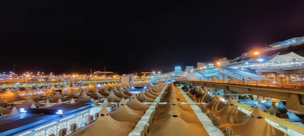 Rows of illuminated tents in Mina glowing at night during the days of Hajj