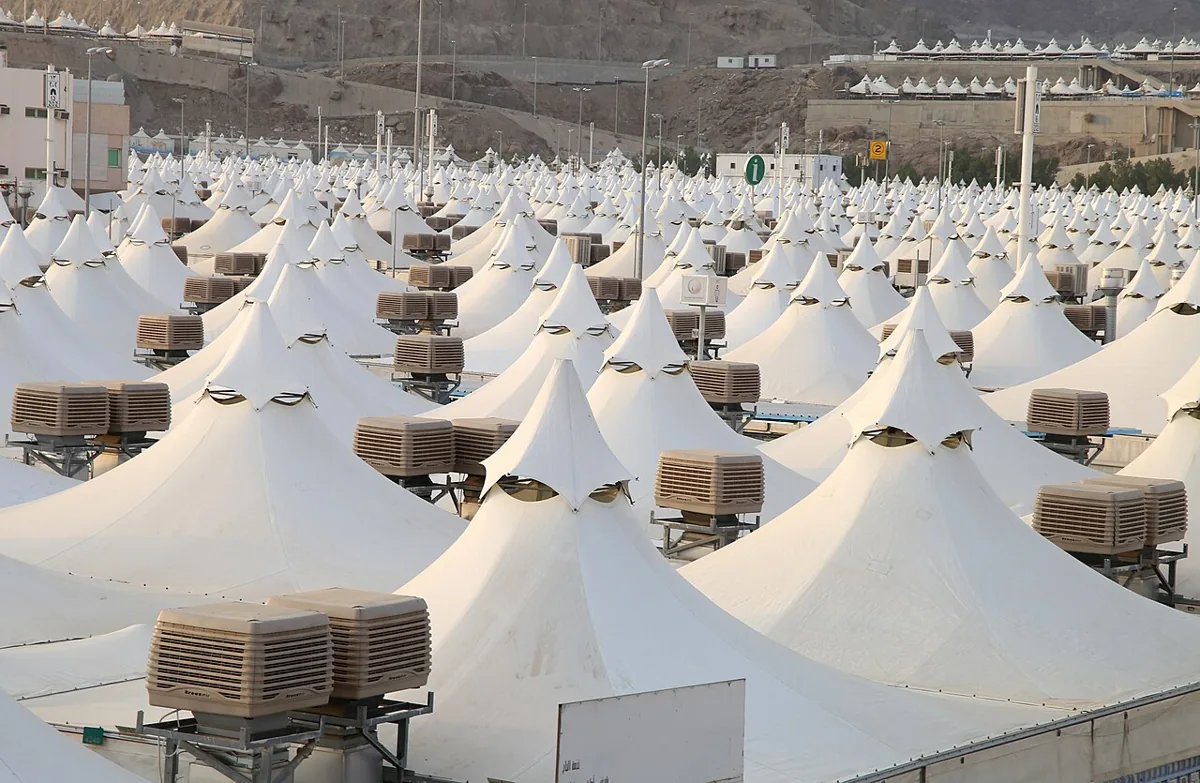 Rows of white pilgrim tents with cooling units in Mina during Hajj