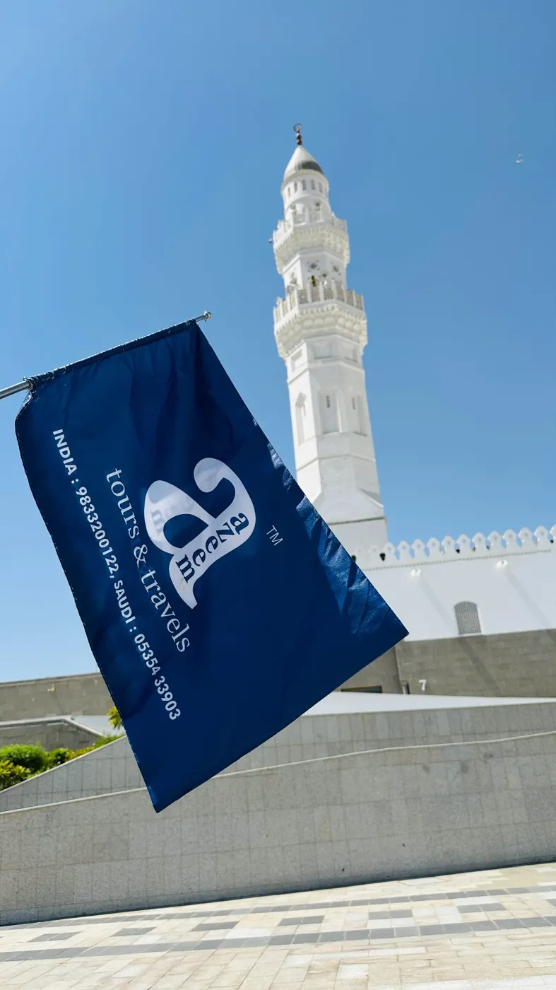 The blue Azeem Tours flag raised before Masjid Quba during the Madinah Ziyarat